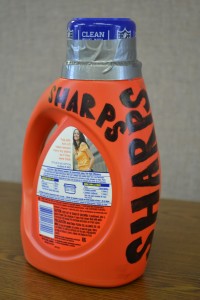 This sharps container should be placed in the trash.